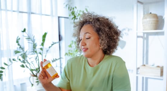 mature woman holding a bottle of medicine in her hand
